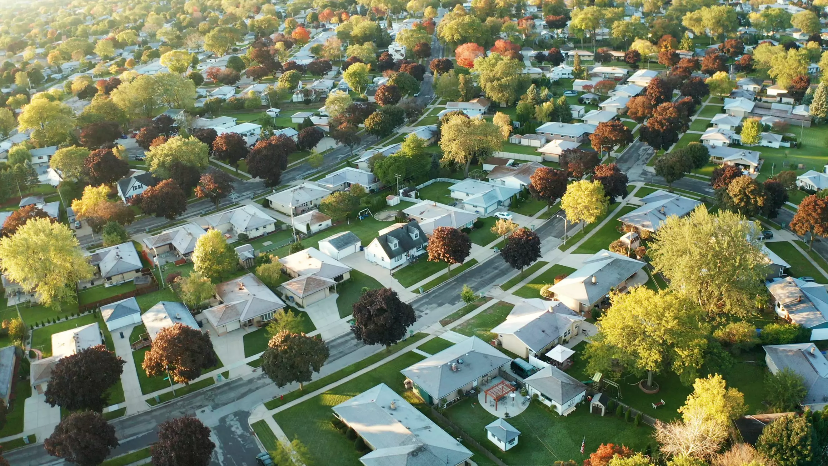 Aerial view of residential houses at autumn (october). American neighborhood, suburb. Real estate, drone shots, sunset, sunny morning, sunlight, from above